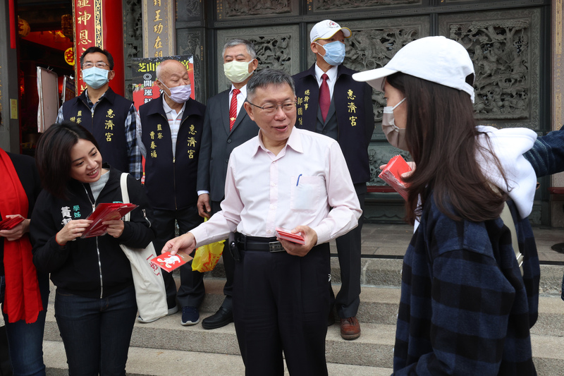 台灣民眾黨主席柯文哲（前中）23日上午赴台北芝山巖惠濟宮發放發財金，向民眾拜年祝賀新年快樂。(圖：中央社 )