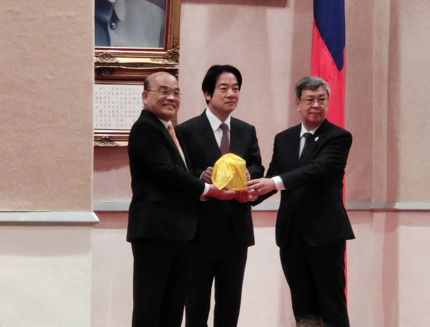 在副總統賴清德(中)監交下，新任閣揆陳建仁(右)從卸任的蘇貞昌(左)手中接下印信，正式就任行政院長。(王韋婷攝)