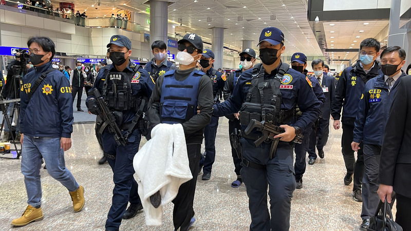 台南學甲槍擊案主嫌「紅龜」洪政軍及槍手孔祥志在中國落網，25日被警方從廈門押解回台，約下午2時40分抵達桃園國際機場，一路由刑事局除暴特勤隊警戒至管制區外，再由台南警方接手。 (圖：中央社)