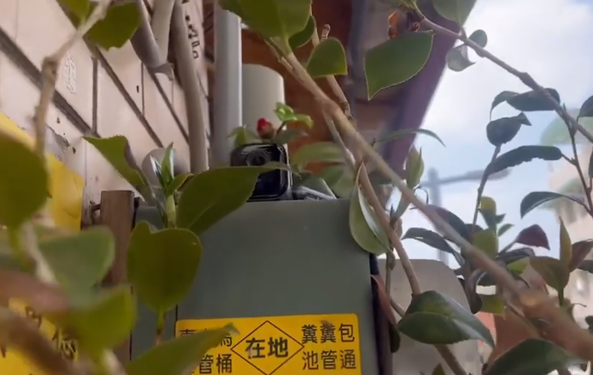 南投縣第2選區立委補選4日投開票，名間鄉濁水福興宮外樹叢間被發現放置攝錄影器材監控投票。(翻攝臉書影片)