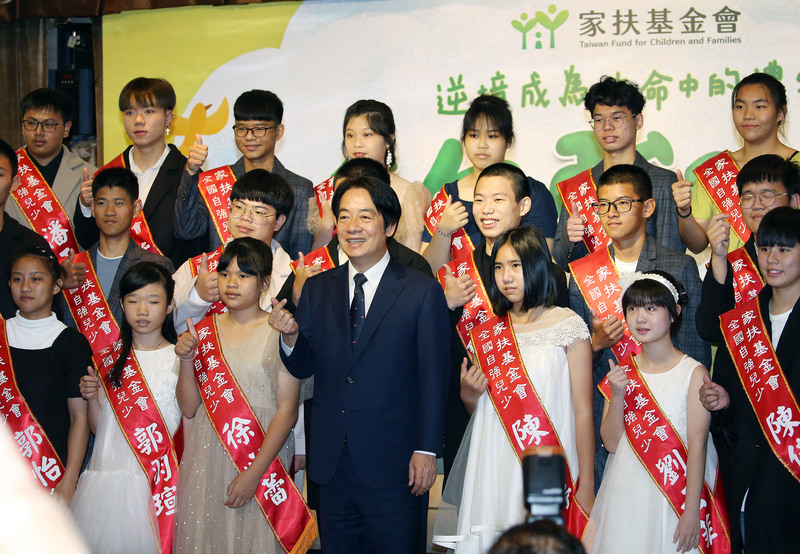 副總統賴清德（前排中）19日出席家扶基金會2023年全國自強兒少表揚活動，與獲獎兒少共同比出愛心手勢合影。 (圖：中央社)