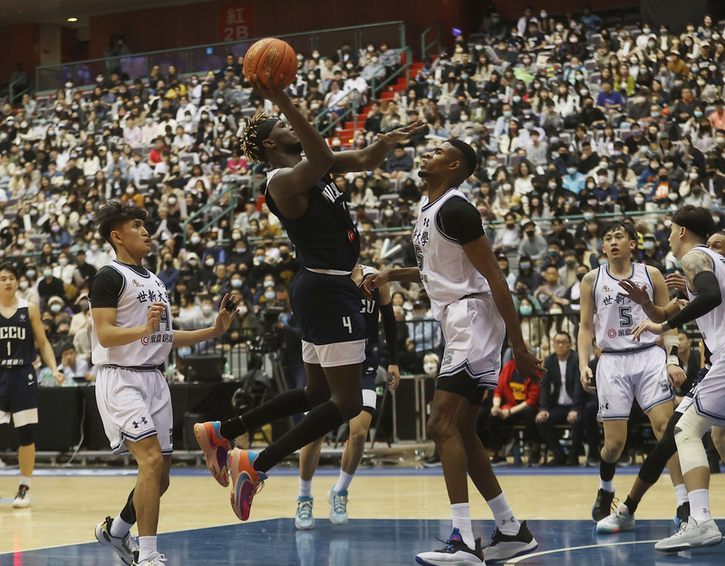 台灣職籃聯合選秀會禁止外籍生參與，政大前鋒莫巴耶(持球者)等8名外籍生表達錯愕。(圖：中央社)