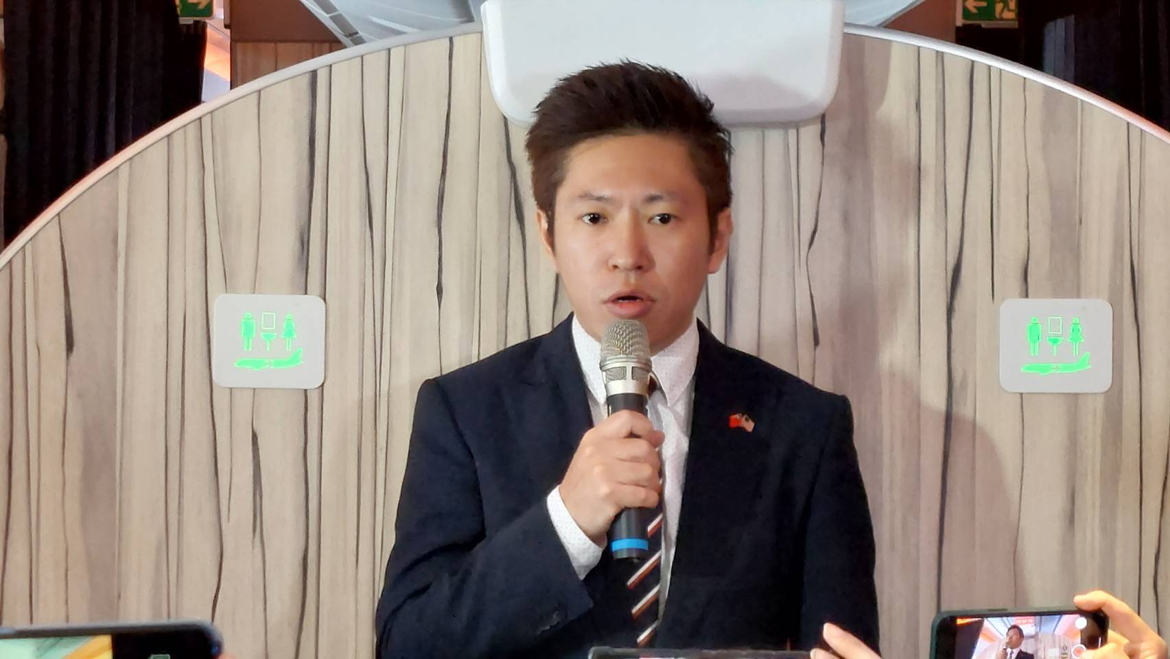 總統府副祕書長張惇涵在專機上說明蔡英文總統與麥卡錫會晤的相關安排。(歐陽夢萍 攝)