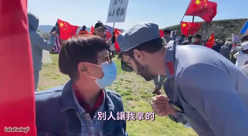 一名拿著擴音器播放抗議口號的中國走路工告訴樂樂法利「別人要我拿的」。   圖：翻攝樂樂法利YouTube影片