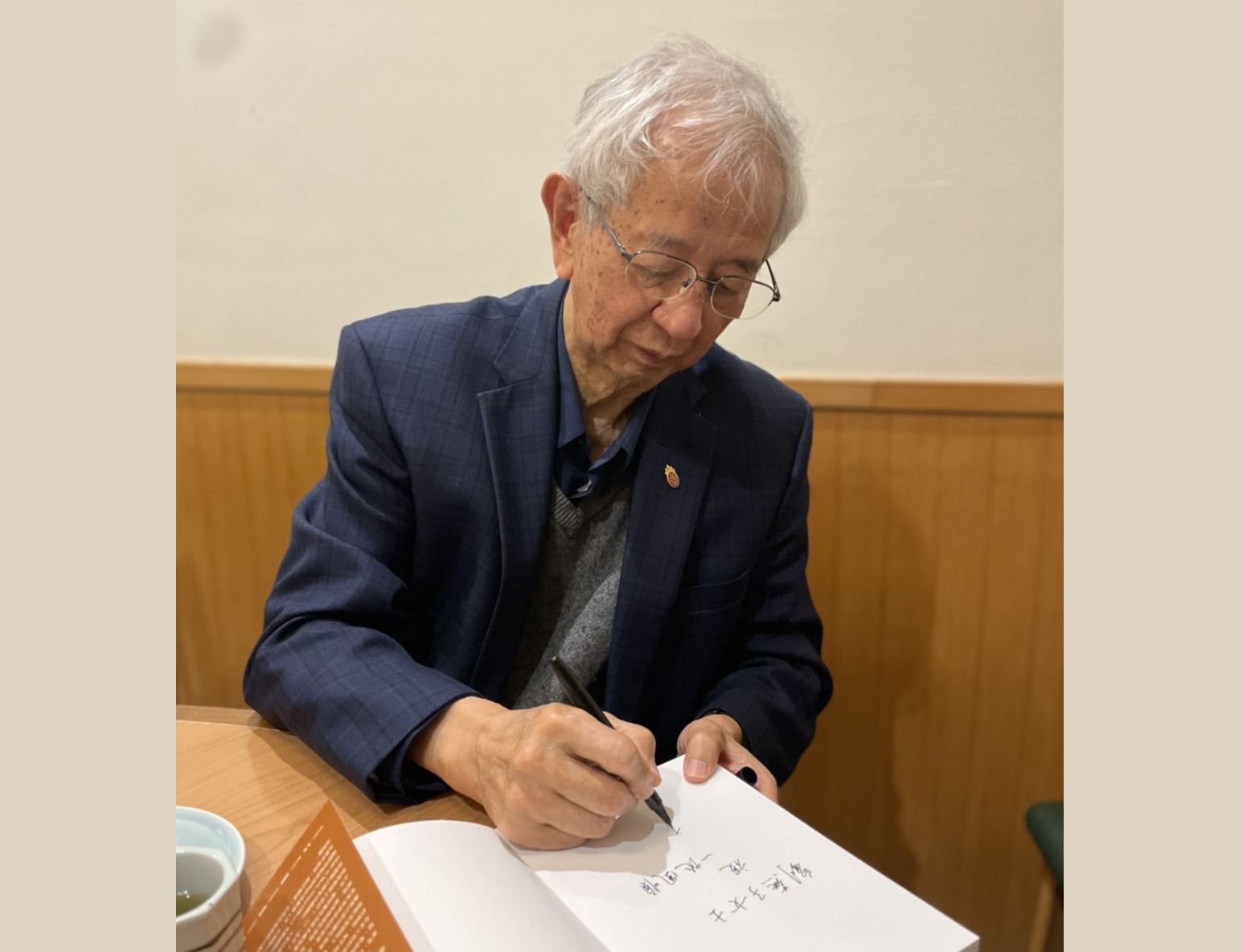 李遠哲先生席間應作者要求，在《李遠哲傳》首頁題字。(圖片：劉老西提供)