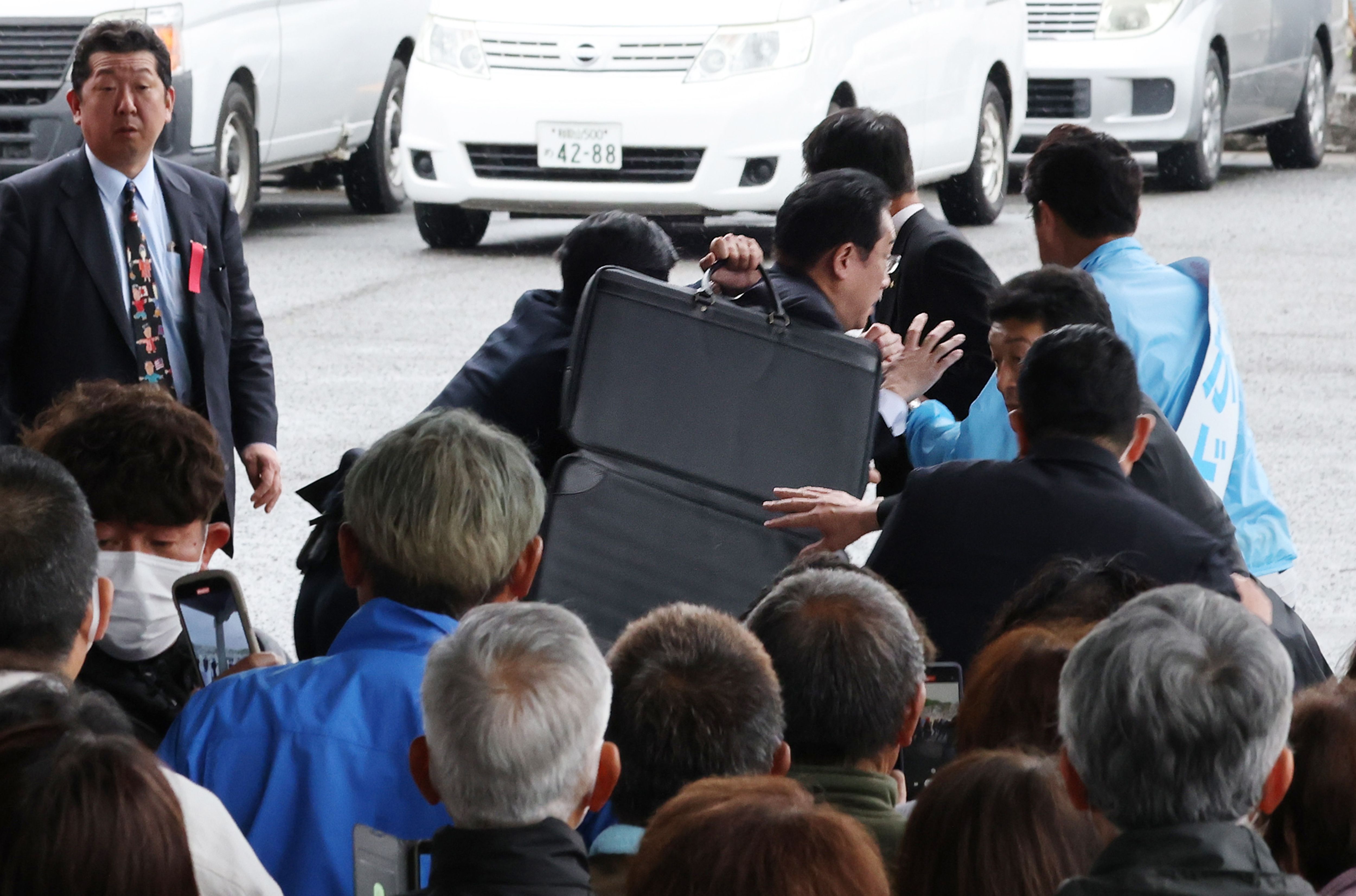 日本首相岸田文雄在安全人員護送下離開。（AFP）