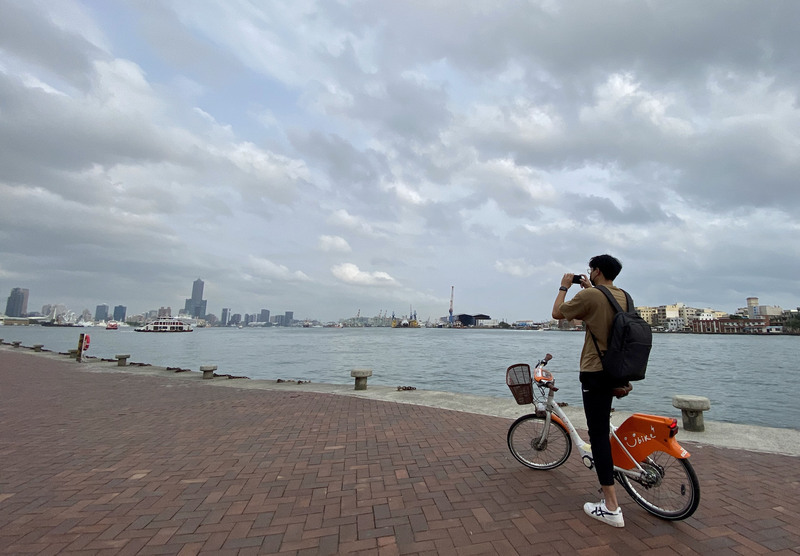 圖為高雄港周邊午後雲層略多但無雨，民眾騎乘單車出遊。 (圖：中央社)