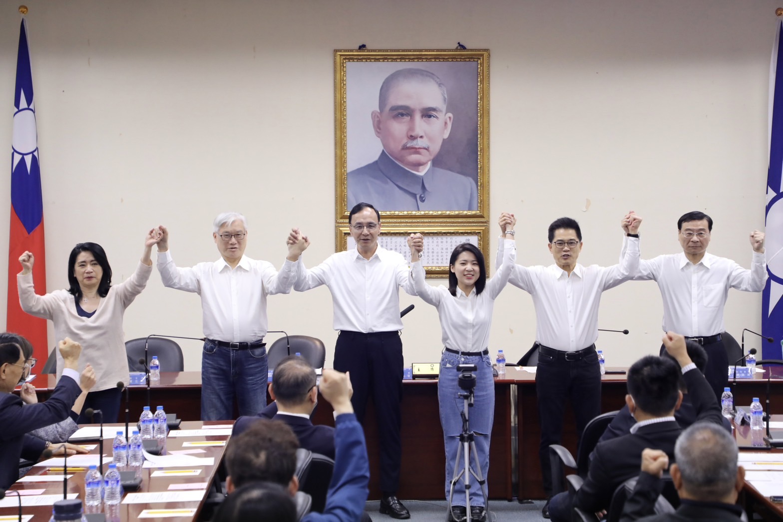 國民黨中常會26日正式通過提名羅明才、徐巧芯參選立委，黨主席朱立倫(中)並牽起兩人的手高喊團結。(國民黨提供)