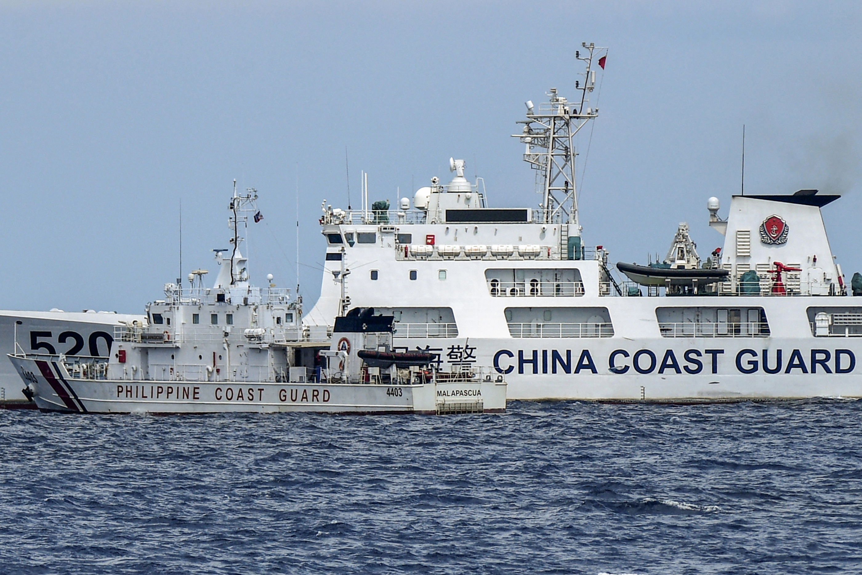 菲律賓海岸防衛隊巡邏艦「馬拉帕茲瓜號」(左)23日駛近南沙群島仁愛暗沙時，中國海警船駛入航道，雙方船艦險相撞。(AFP)
