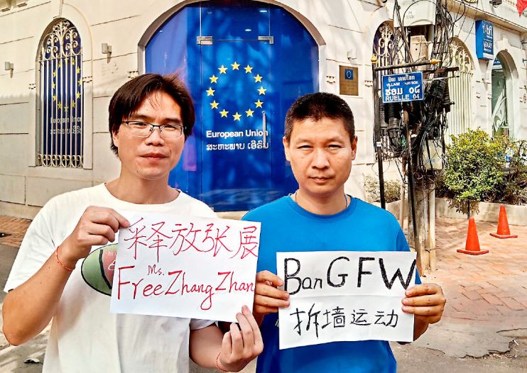 中國海外民主派人士發起「拆牆運動」，在歐盟駐永珍使館前舉牌，圖左為發起人喬鑫鑫。（取自網路）