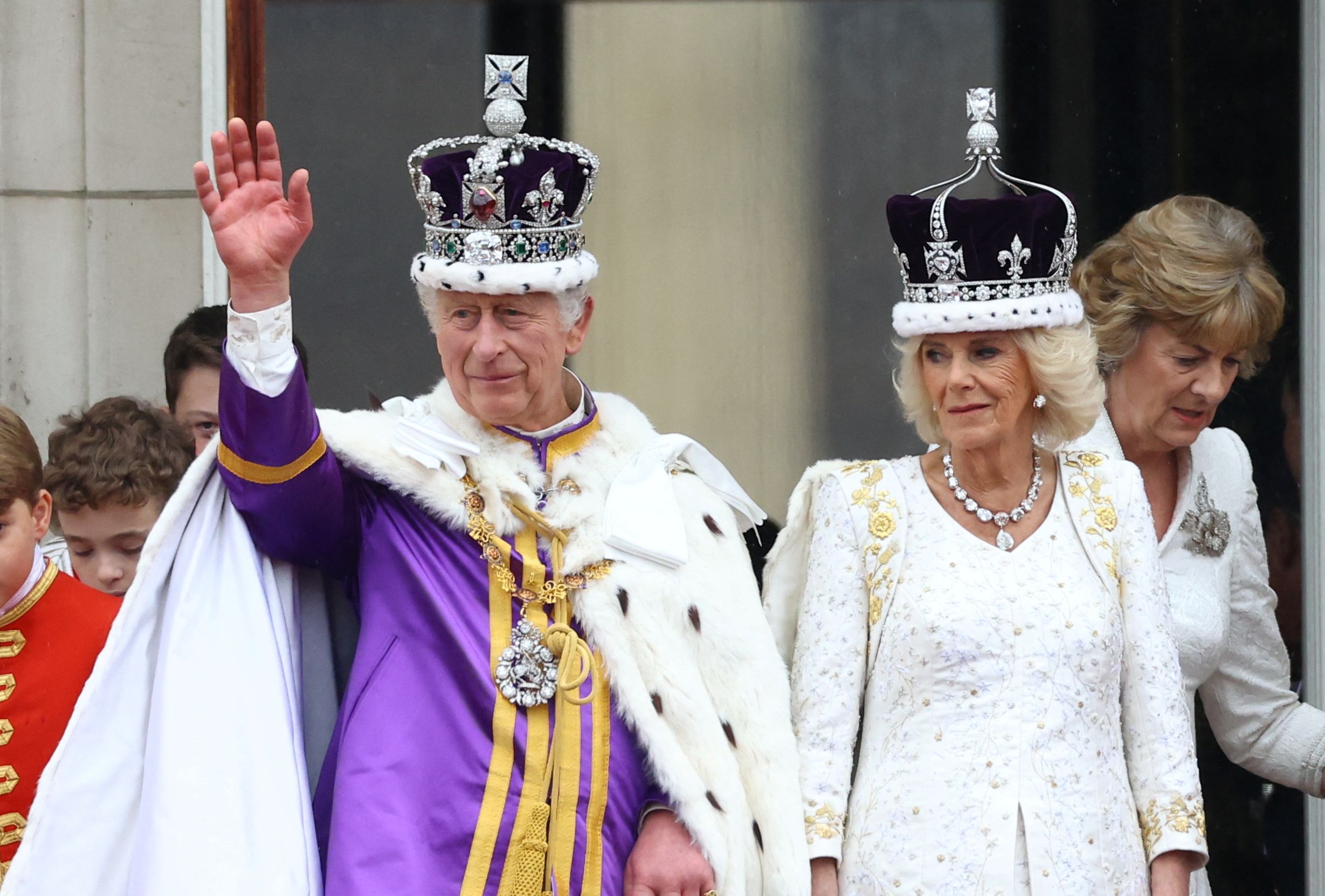 英國國王查爾斯三世(Charles III)和王后卡蜜拉(Camilla)6日加冕典禮結束後，回到白金漢宮向民眾揮手致意。 (路透社/達志影像)