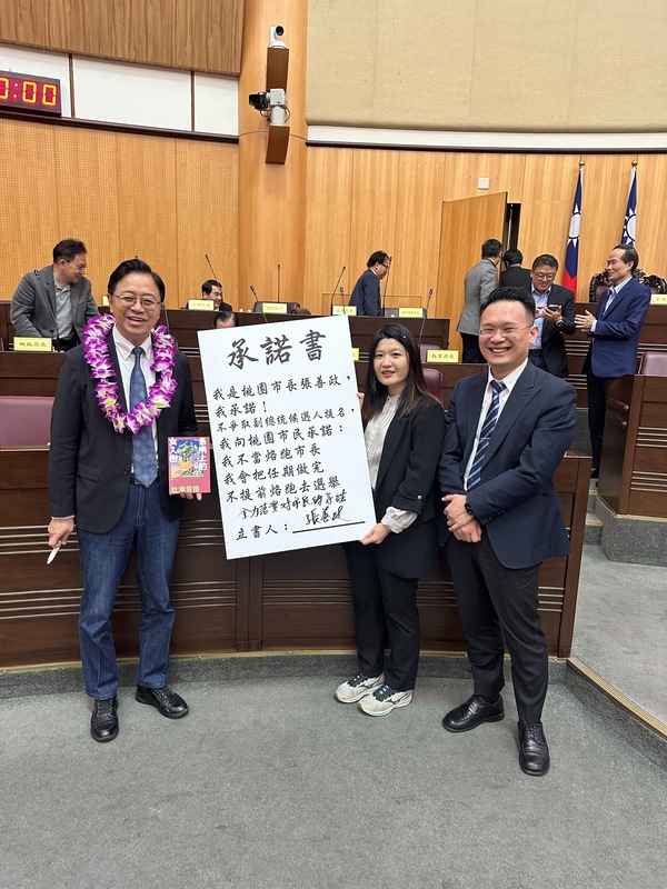 桃園市長張善政（前左）18日在桃園市議會備詢時，簽下由民進黨議員魏筠（前右2）製作的「不當落跑市長」承諾書，也不爭取副總統候選人提名。（魏筠提供） (圖：中央社)
