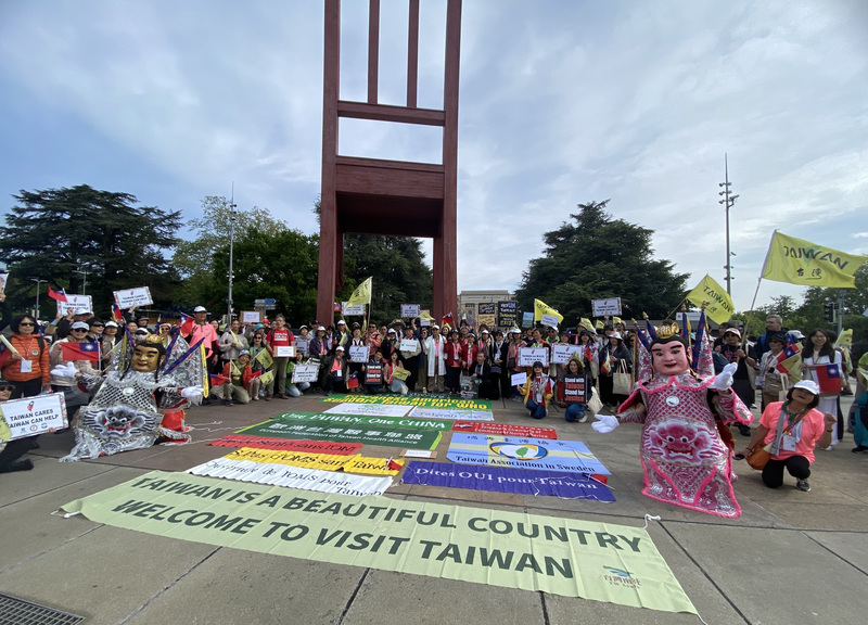 世界衛生大會(WHA)開議前夕，台僑、民間團體、歌手近500人20日集結在日內瓦聯合國辦事處前三腳椅廣場，進行「台灣大遊行」，氣氛歡樂，以民間人士和意見領袖串連力量向國際發聲。(圖：中央社)