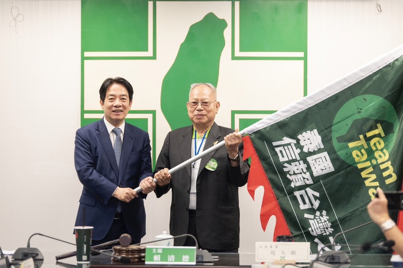 黨主席暨總統參選人賴清德（左）14日出席「泰國信賴台灣之友會」籌備會議，賴清德現場授戰旗給泰國信賴之友會總會長黃員教（右），全場高喊「2024團結一致」、「Team Taiwan，挺台灣」等口號。(圖：中央社)