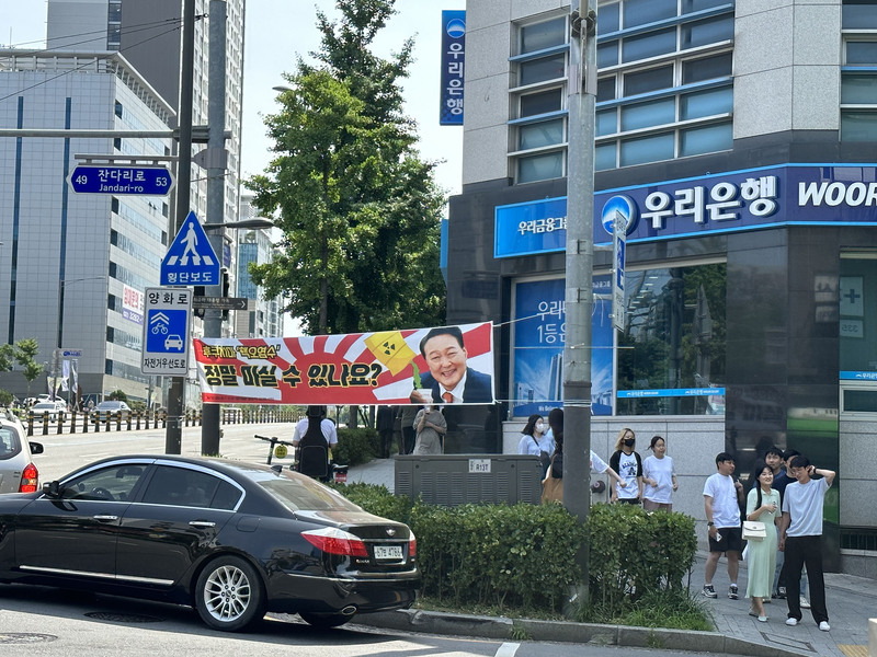 日本福島核廢水排放入海計畫在韓國引發反對聲浪，圖為首爾街頭懸掛質疑核廢水能否飲用的標語。 (圖：中央社)