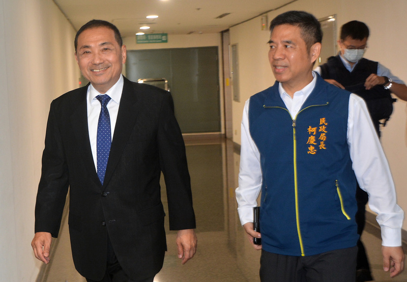 新北市長侯友宜（左）6日參加112年特優里長及績優民政人員表揚活動，面對媒體微笑致意。前右為新北市民政局長柯慶忠。 (圖：中央社)