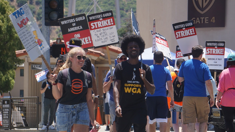 調查顯示，有半數美國人支持好萊䲧編劇演員罷工。圖為今年7月間華納兄弟(Warner Bros)製片廠外的抗議人潮。 (圖：中央社)