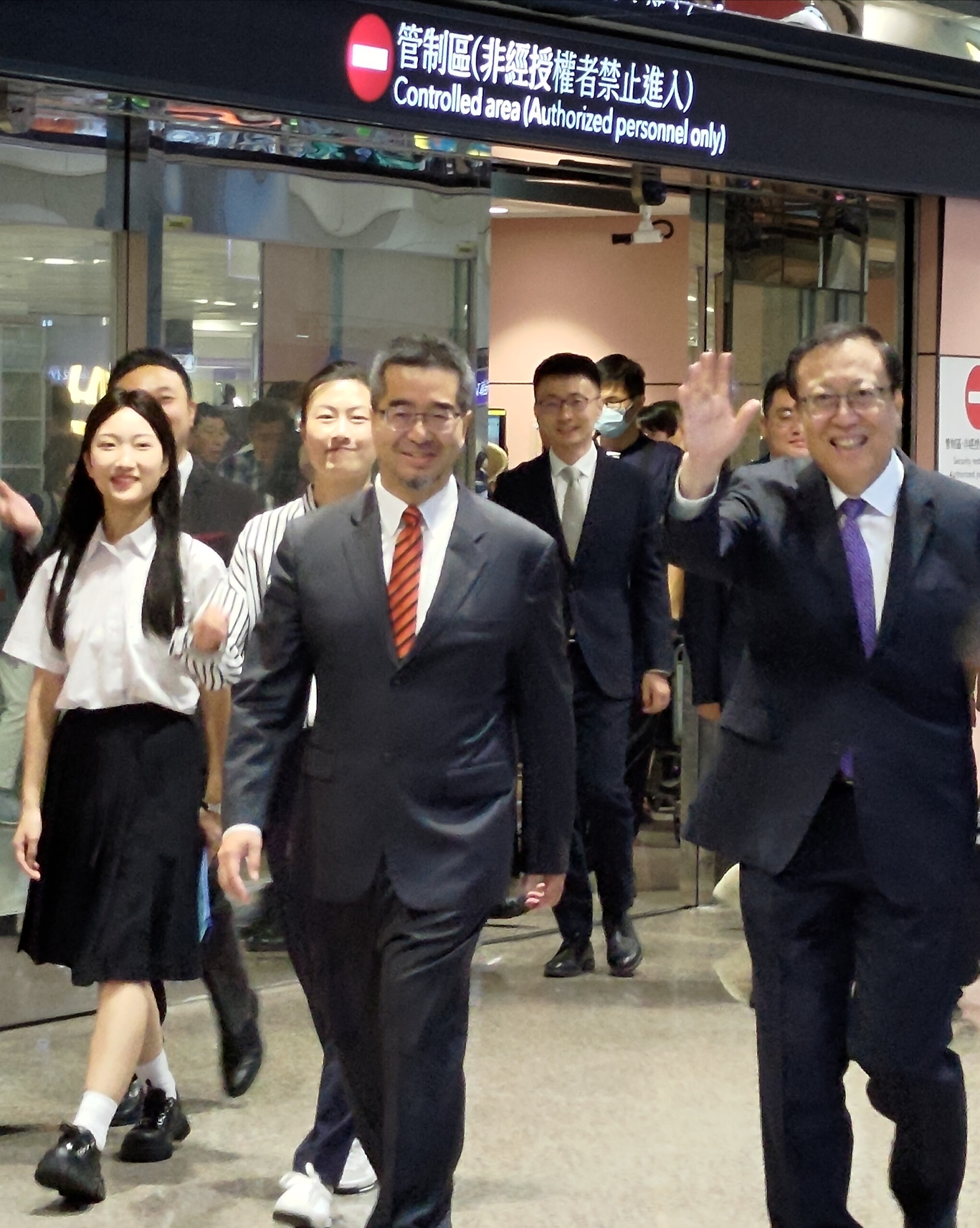 馬英九基金會執行長蕭旭岑(前排左)到機場迎接陸生團，北京大學黨委書記郝平(前排右)向媒體揮手致意，蕭旭岑後方身著條紋襯衫的女學生，則是中國大陸前桌球國手丁寧，她曾在2016年拿下奧運金牌，目前在北京大學攻讀第二個碩士學位。(陳國維 攝)