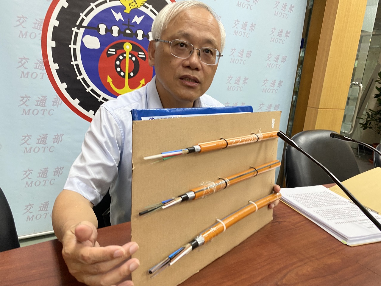 台鐵電務處長劉裕庭18日說明近期完成了2千多公里長的「平交道遠端監視傳輸光纖化工程」，並展示所使用的部分光纖電纜。(吳琍君 攝)