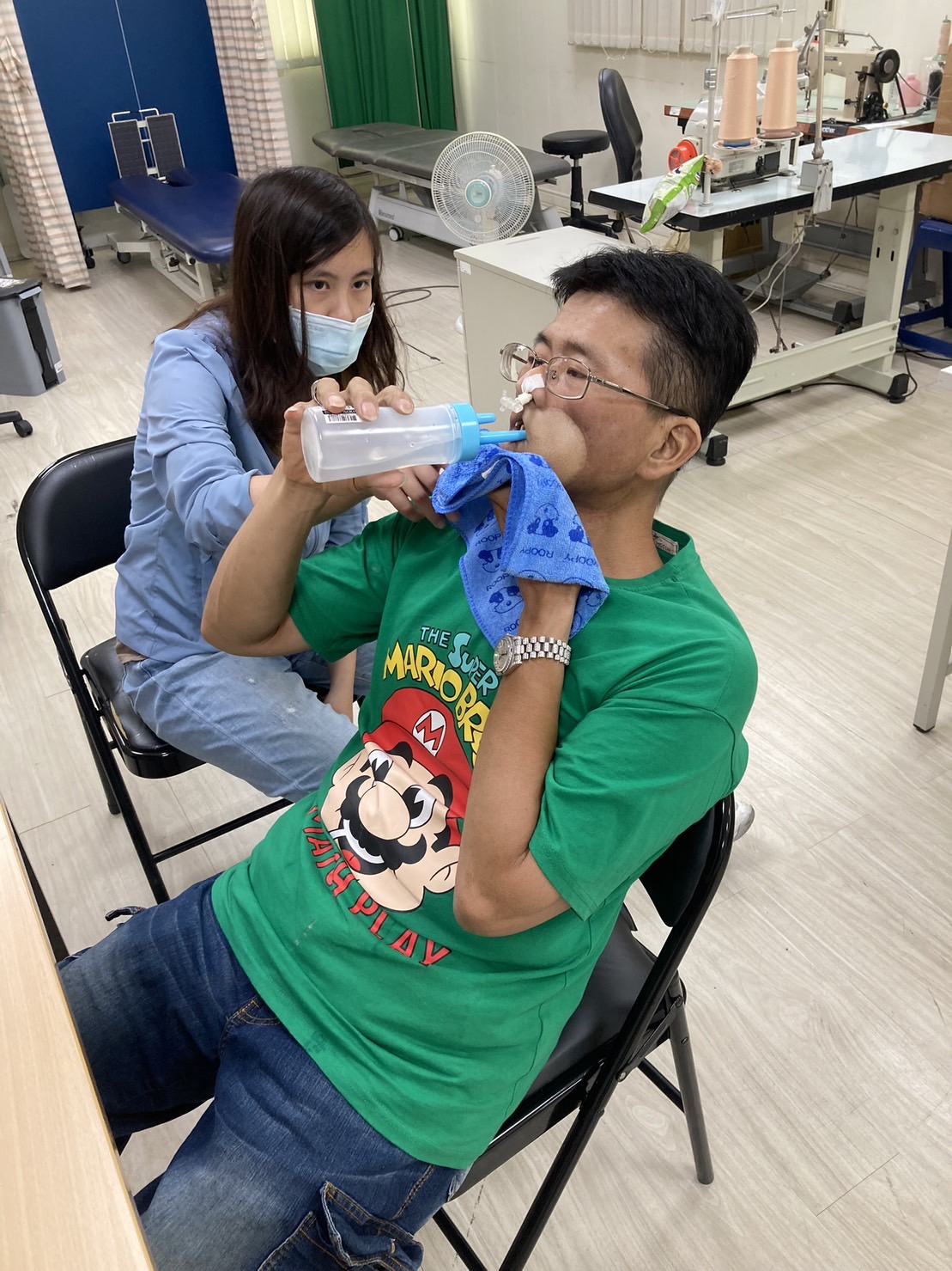 阿志在陽光基金會治療師指導下，練習以口進食。(陽光基金會提供)