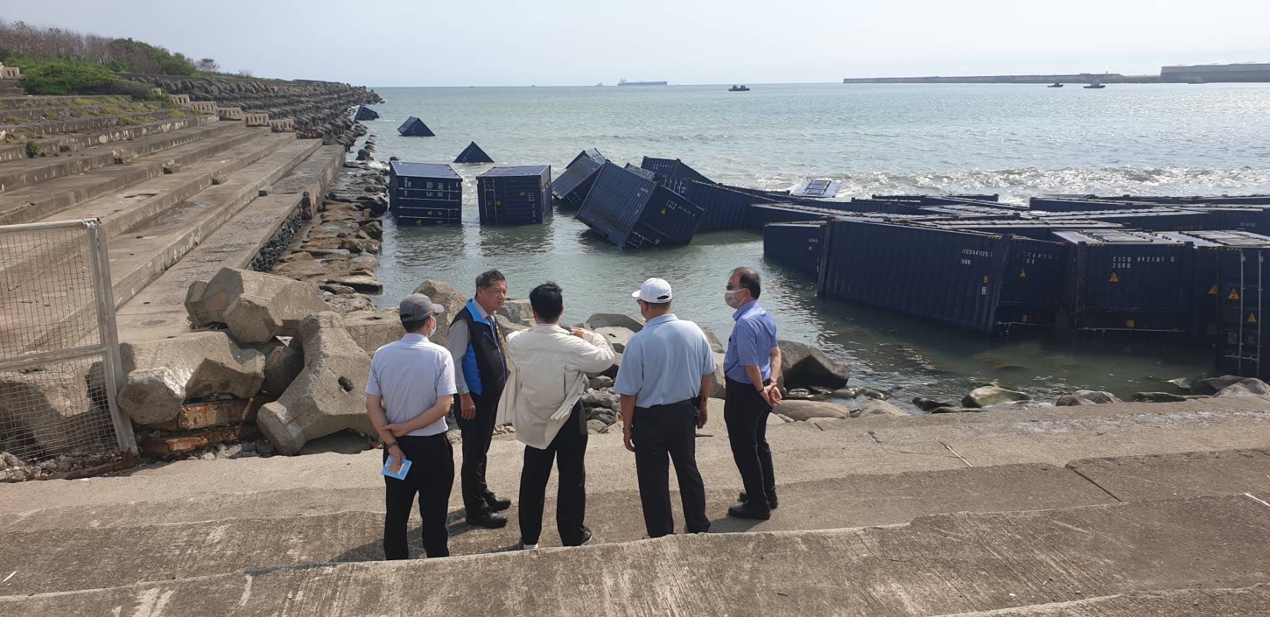 交通部次長祁文中(圖中)24日下午進駐高雄港應變中心，並前往岸邊視察天使輪空貨櫃卡在消波塊的情形。(台灣港務公司提供)