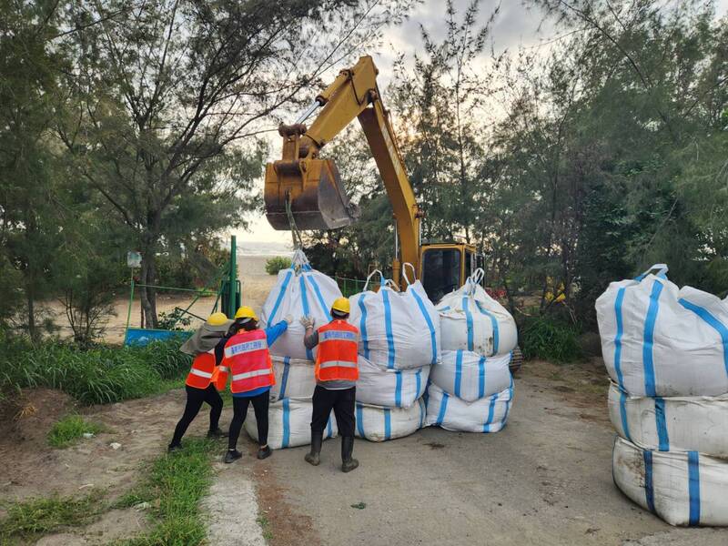 颱風杜蘇芮逼近，台南市政府已調動機具趕往南區濱南路段臨海側，堆砌太空包堵住防風林缺口，避免強風捲沙造成路面積沙。 (圖：中央社)