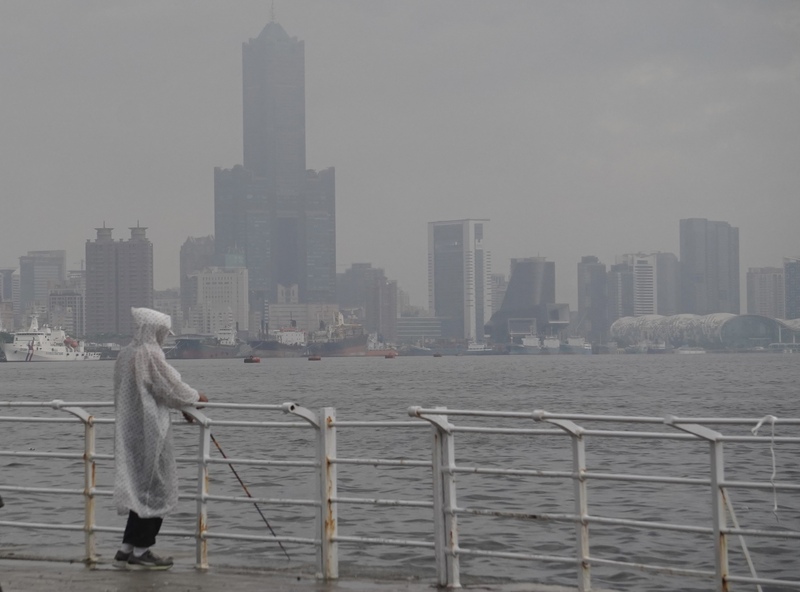 杜蘇芮颱風影響，交通部提醒民眾留意可能受影響的海陸空交通資訊。圖為民眾身穿雨衣觀看雨勢。 (圖：中央社)