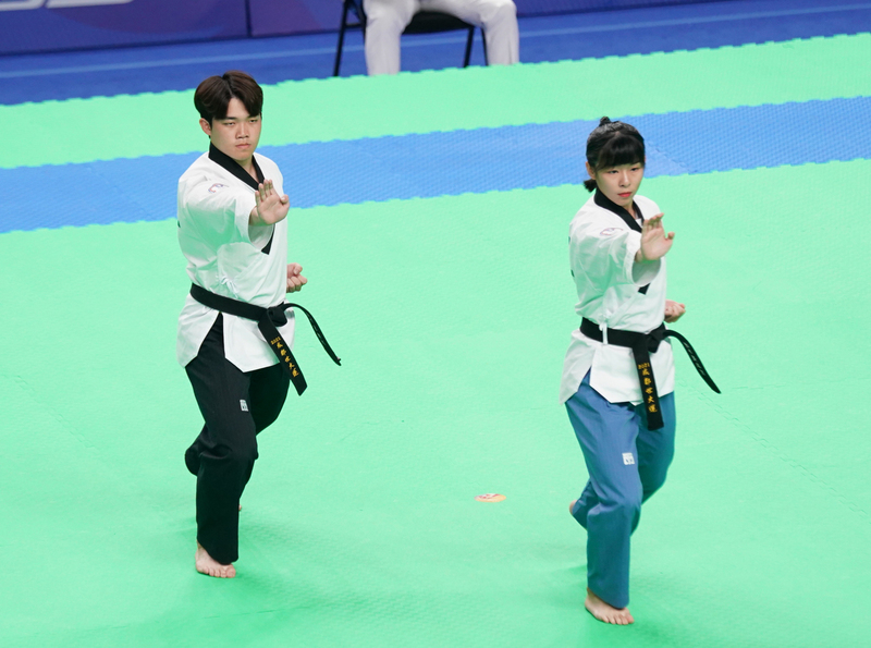 台灣組合黃品潔(右)、徐語澤(左)30日在成都世界大學運動會跆拳道混合雙人品勢決賽展現默契，以總分6.910分拿下銅牌。(大專體總提供)