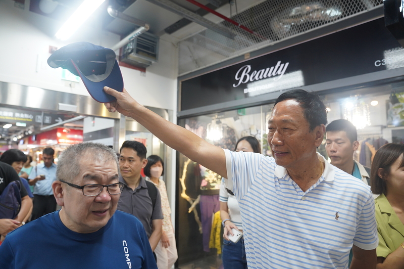 鴻海集團創辦人郭台銘（前右）11日上午前往台北市南門中繼市場，向攤商致意。 (圖：中央社)