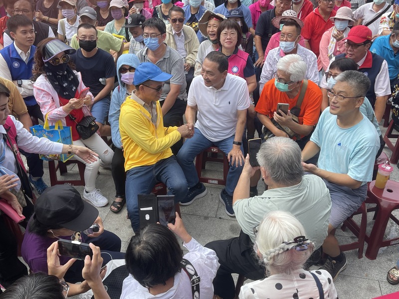 國民黨總統參選人侯友宜（前中，白衣者）12日走訪台南，上午在北區大觀音亭暨興濟宮前與支持者交談、握手致意。 (圖：中央社)