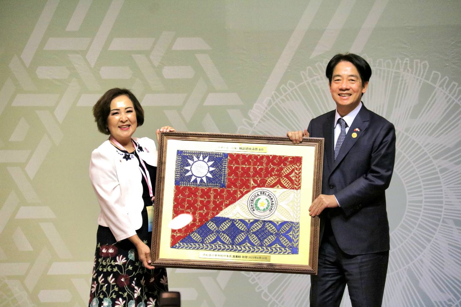 巴拉圭僑界致贈賴清德(右)一幅將台、巴兩國國旗編織在一起的蜘蛛鏽，象徵兩國邦誼穩固緊密。(歐陽夢萍 攝)