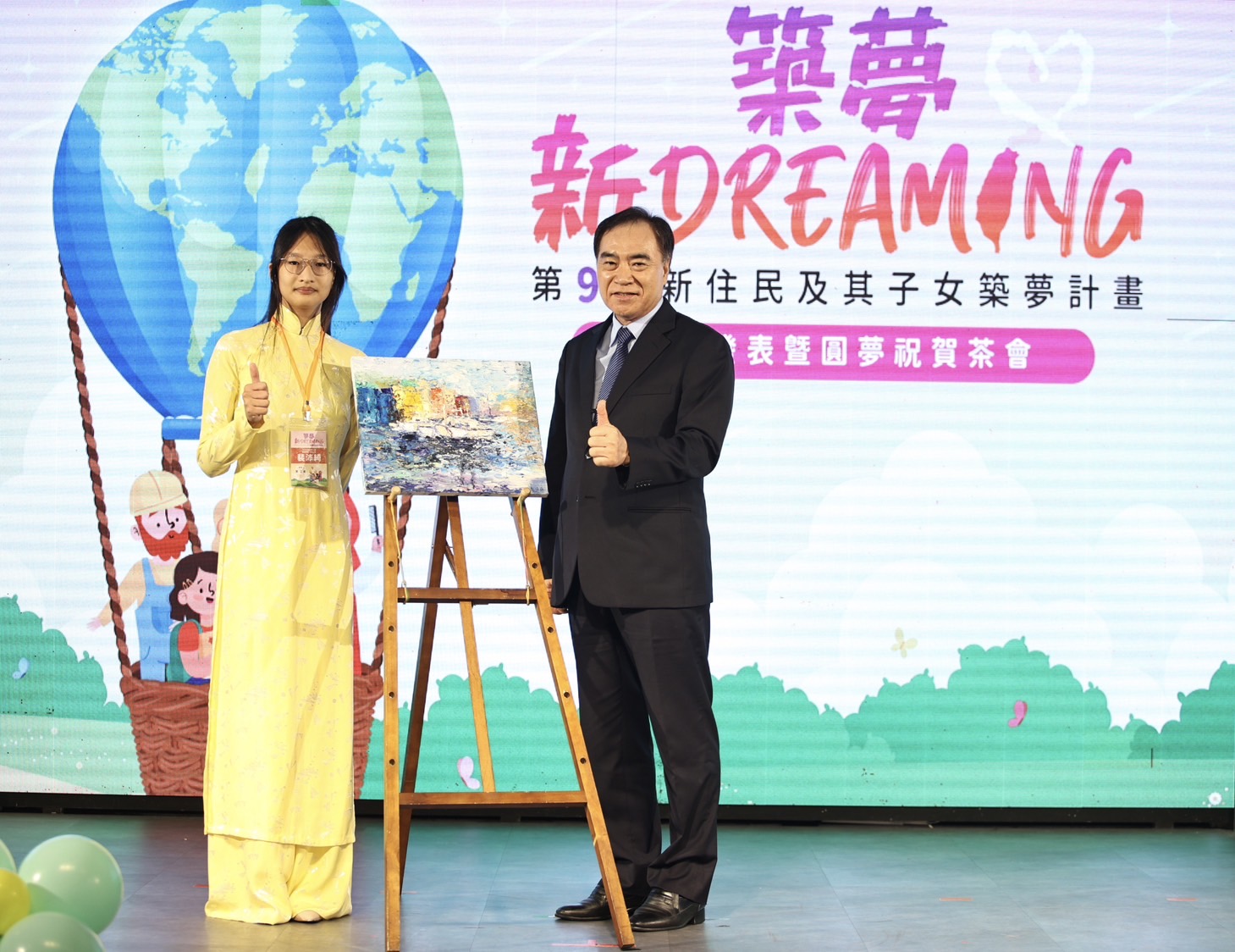內政部政務次長吳容輝出席第9屆築夢計畫成果發表暨圓夢祝賀茶會，並與獲獎者裴沛綺及其畫作合影。(圖：移民署)