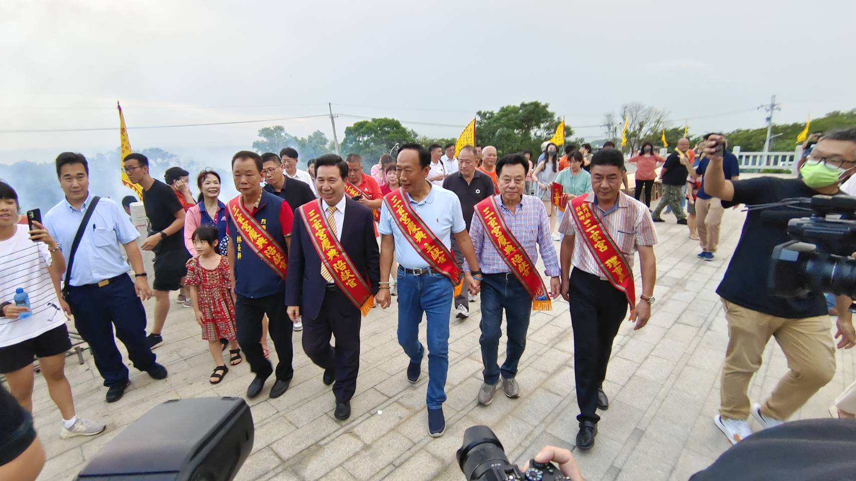 鴻海集團創辦人郭台銘赴小金門參拜三玄宮，金門縣長陳福海(左二)現身陪同，郭台銘、陳福海、金門縣議會議長洪允典(右二)手牽手一起進入宮內參拜。(王韋婷攝)