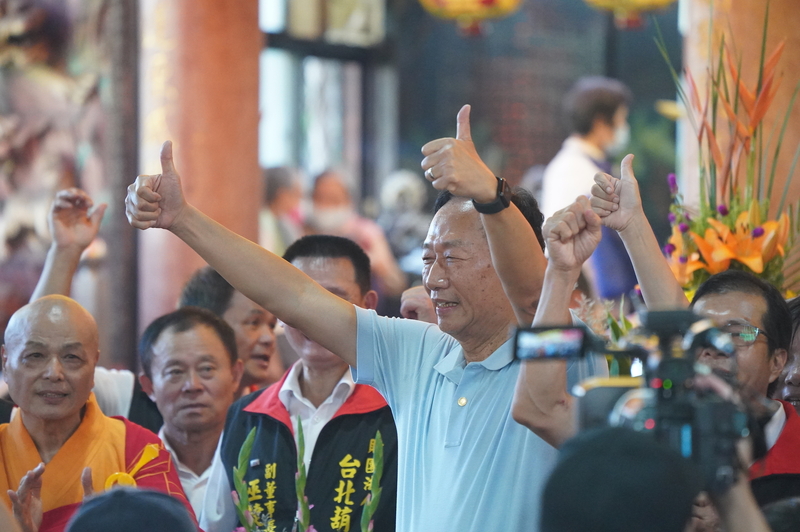 鴻海創辦人郭台銘(中)25日前往台北市士林區葫蘆寺參加中元普渡超薦大法會，雙手比讚接受媒體拍攝。(圖：中央社)