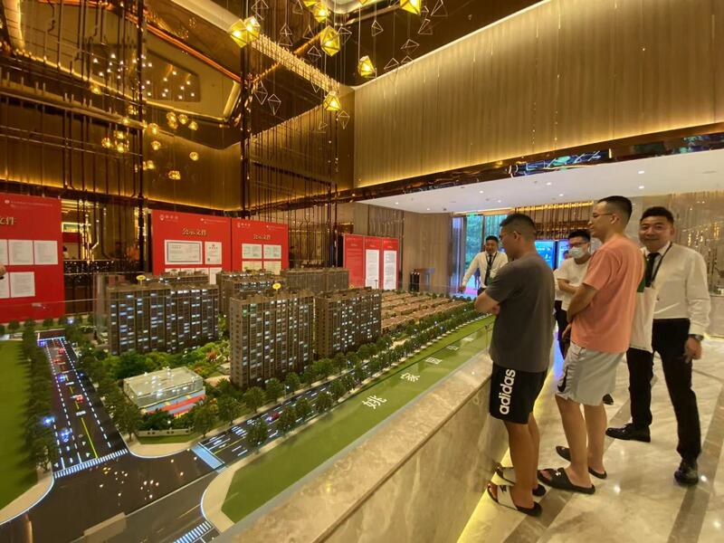 中國首都北京在1日實施「認房不認貸」政策，多個樓盤銷售連夜通宵營運吸客。圖為北京一樓盤御翠園的接待中心，以及前來了解該房產的買家。 (圖：中央社)