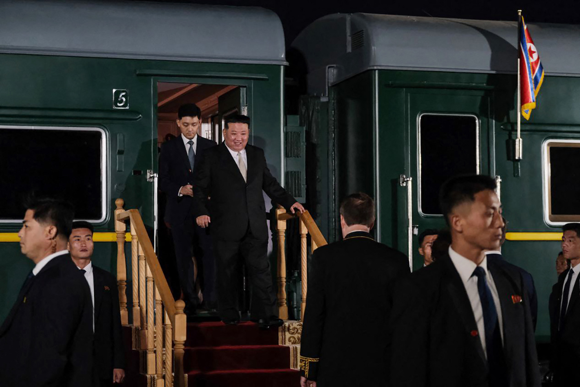 北韓領導人金正恩12日搭乘專門列車抵達俄羅斯後，走下火車並受到俄羅斯官員迎接。(AFP)