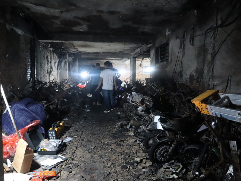 越南首都河內市一棟迷你公寓12日深夜發生火警，起火點疑似位於一樓的停車場，火勢與濃煙堵住了整棟大樓位於一樓的唯一出口，導致56人死亡。圖為事故現場一樓的停車場，兩排機車與電動車被燒焦。 (圖：中央社)