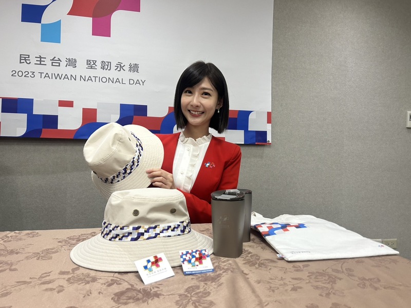 112年國慶大會國慶大會主持人之一的莊惠琪22日展示今年國慶大會禮賓紀念品，包含國慶徽章、超輕純鈦杯等台灣製造商品。(圖：中央社)