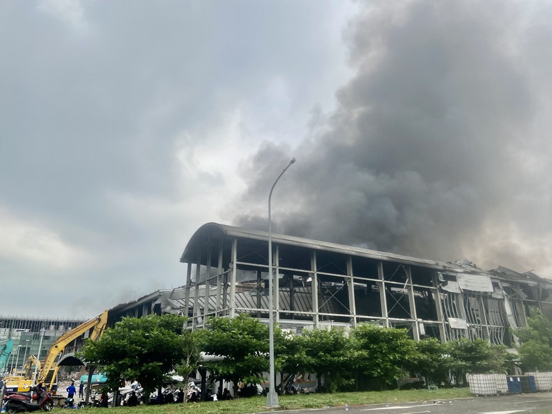 屏東科技產業園區內的明揚國際科技股份有限公司工廠22日傍晚發生火警，23日上午現場仍有陣陣濃煙竄出，救援單位動用大型機具進入清理廠區。 (圖：中央社)