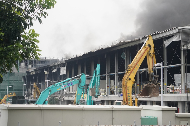 屏東科技產業園區內的明揚國際廠房22日傍晚發生火警，廠區23日持續延燒，救援單位動用大型機具進入清理廠區。 (圖：中央社)