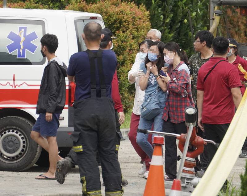 屏東科技產業園區明揚國際科技股份有限公司廠房大火，現場23日中午又找到1具男性員工遺體，搜救人員請來家屬隨至救護車指認遺體，指認的家屬痛苦失聲，悲痛不已。(圖：中央社)