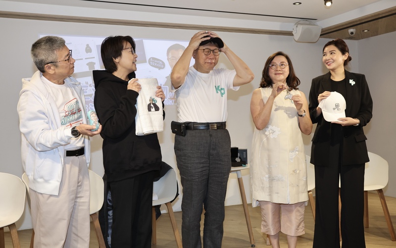台灣民眾黨總統參選人柯文哲（中）27日在台北公布包括浴巾、療癒吊飾、鑰匙圈、棒球帽等第3波競選小物並開箱競選官網，圖為柯文哲戴上刺繡圖案棒球帽供媒體拍攝。 (圖：中央社)