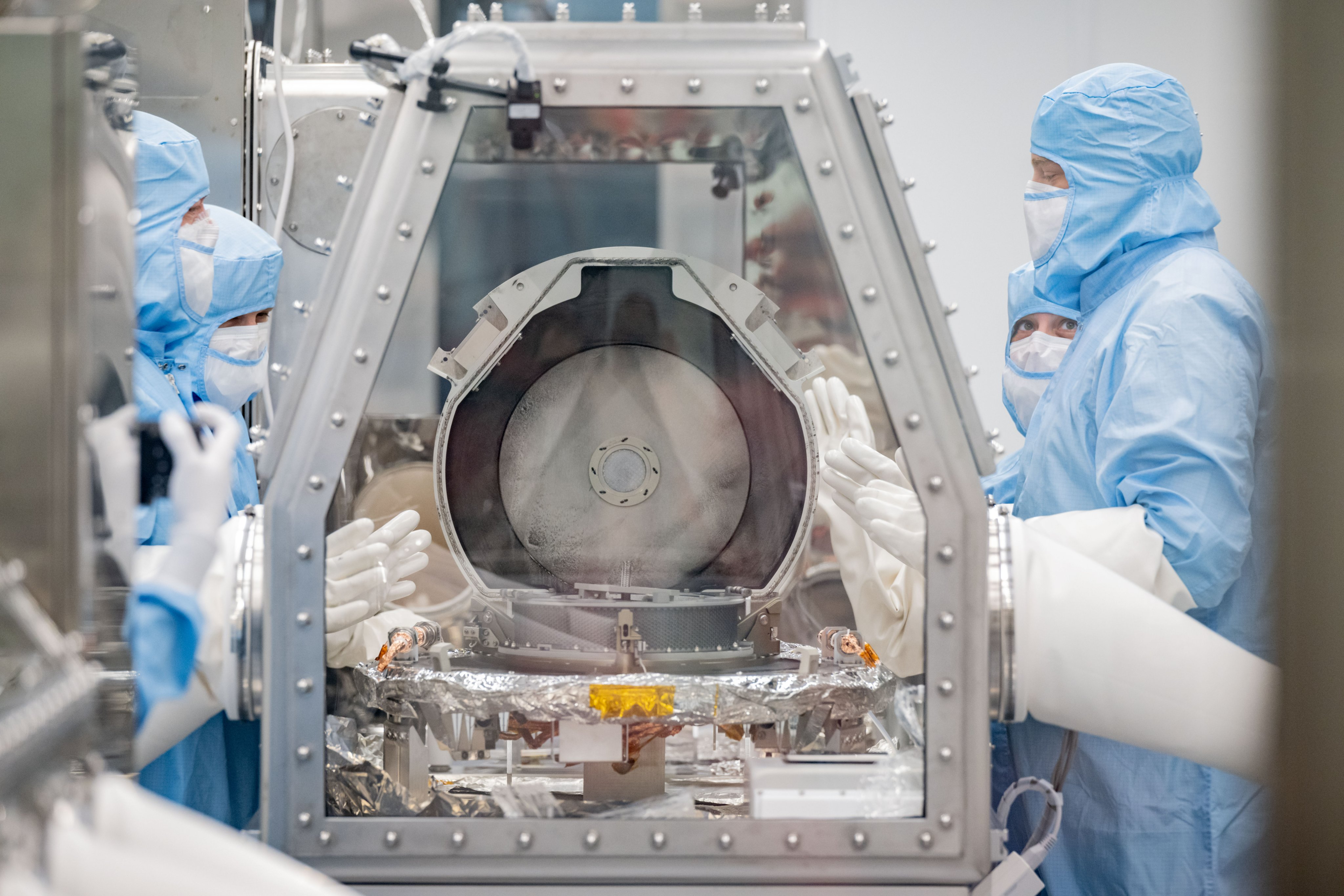 NASA科學家26日打開把小行星樣本帶回地球的太空探測器「歐塞瑞斯號」樣本罐，發現黑色碎片。(圖：@Astromaterials推特)