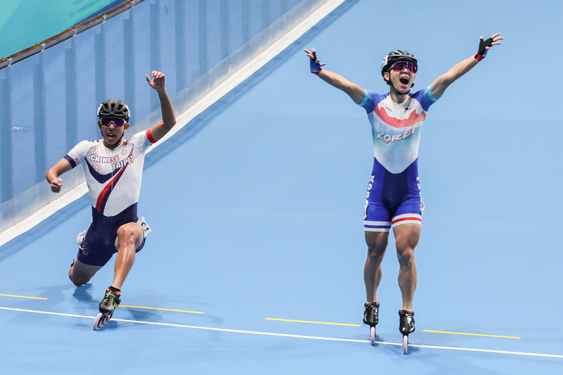 杭州亞運滑輪溜冰項目競速溜冰3000公尺接力賽2日登場，男子組決賽台灣滑輪好手黃玉霖（左）擔任最後一棒，壓線險勝韓國，以4分05秒692成績勇奪金牌。 (圖：中央社)