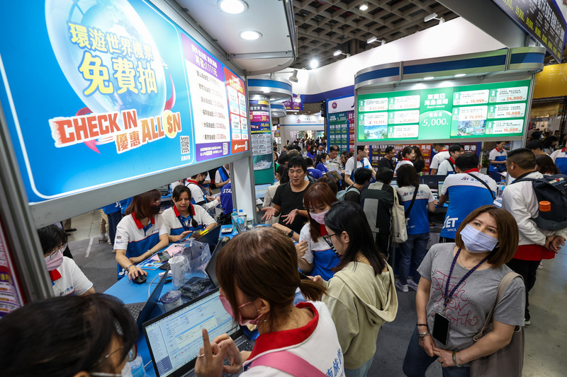 台北國際旅展6日最後一天，業者紛紛祭出優惠促銷搶客，不少民眾在展場攤位選購優惠行程。(圖：中央社)