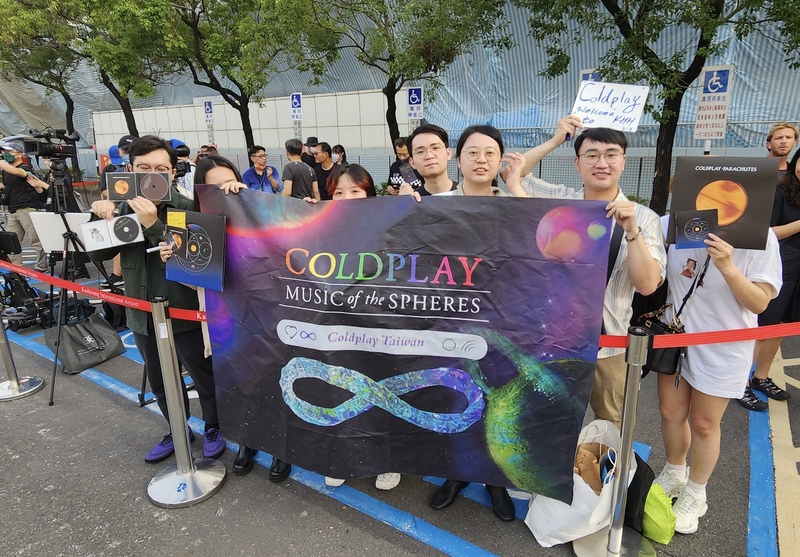 英國搖滾天團Coldplay 10日下午抵達高雄小港國際機場，現場多名粉絲高舉海報、專輯，歡迎成員們來到高雄。 (圖：中央社)