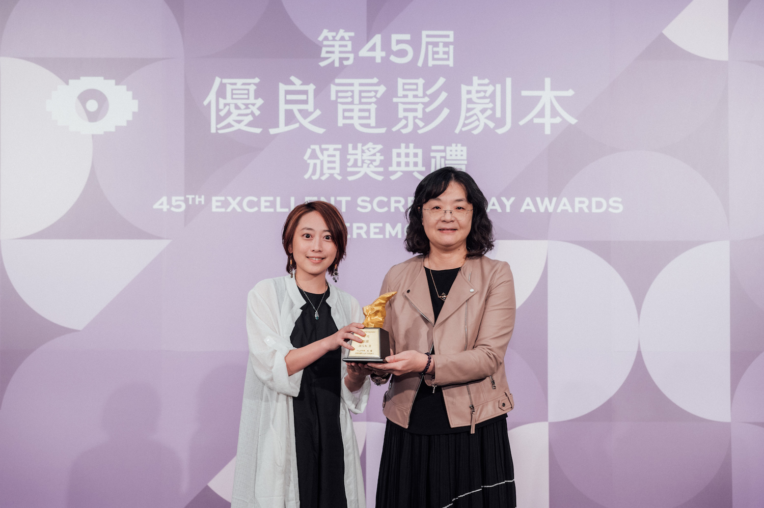 文化部常務次長徐宜君（右）頒獎給首獎得主〈惡潮〉謝家忻（左）。(金馬執委會提供)