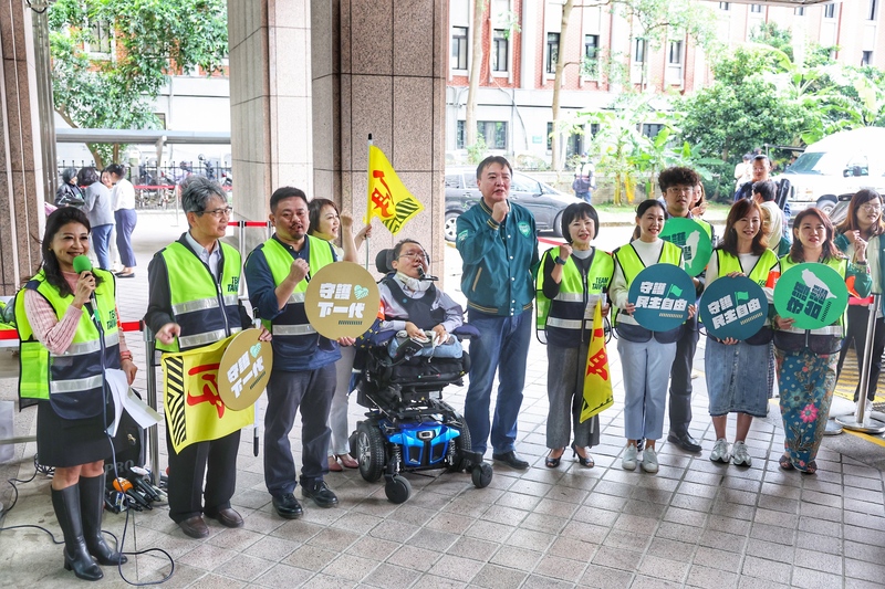 民進黨不分區立委參選人24日上午前往中選會完成登記，民進黨祕書長許立明（前右5）與眾人一同喊口號。 (圖：中央社)