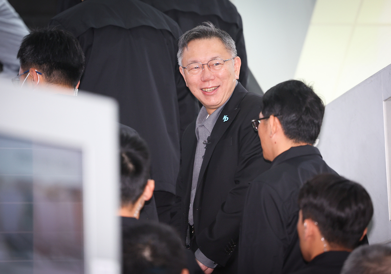 台灣體外維生系統學會第3屆第1次會員大會在台大醫院國際會議中心舉行，台灣民眾黨主席暨總統參選人柯文哲在登記參選後，25日首度現身活動，他入場時面對媒體提問面露微笑，未多做回應。(圖：中央社)