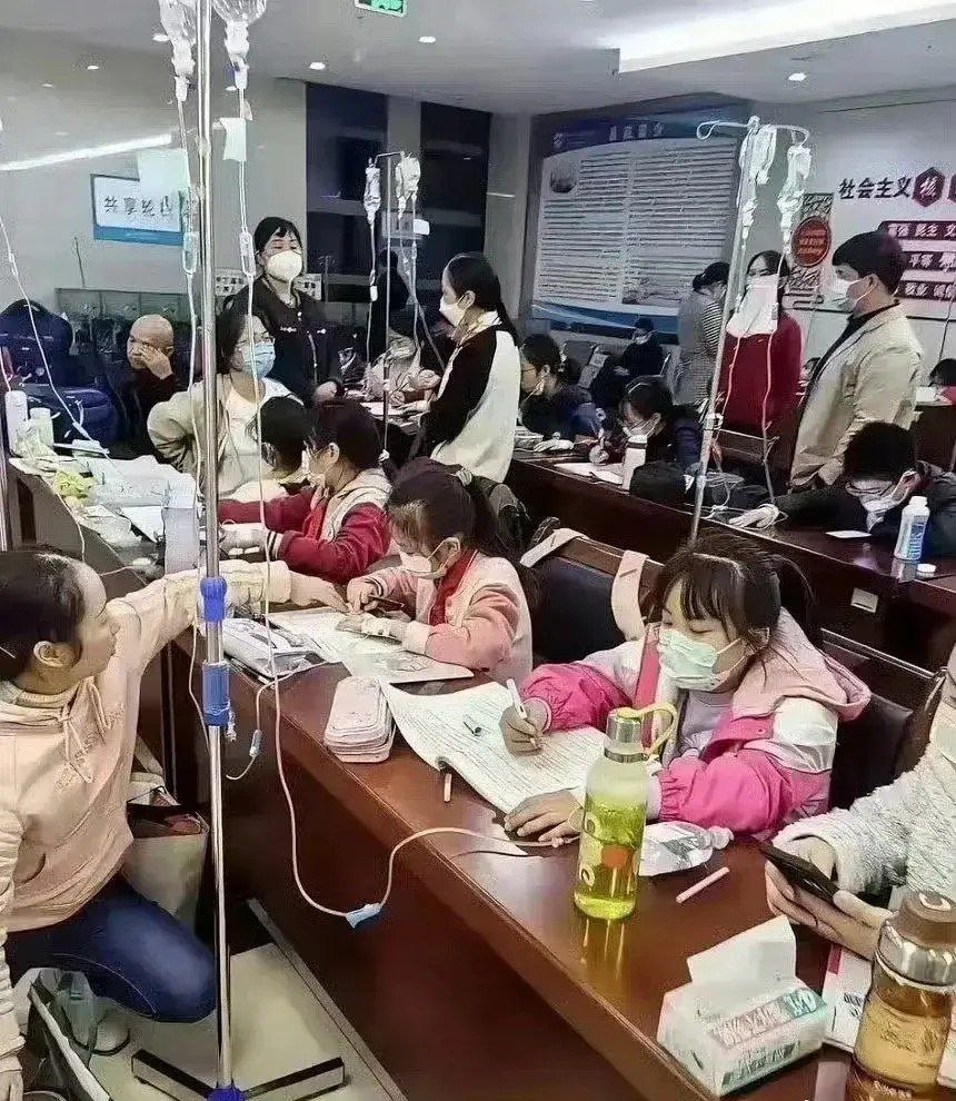 中國爆發多重流感，許多兒童染病，醫院兒科人滿為患，病童得邊打點滴、邊寫作業。(微博金